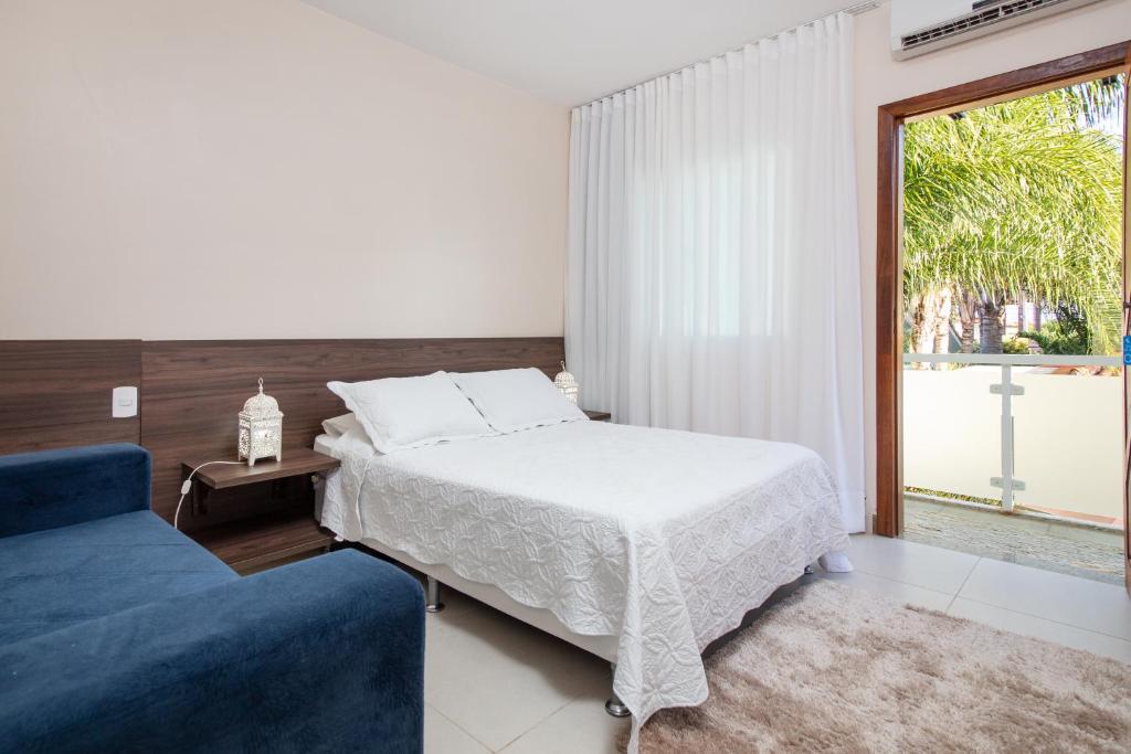 布希奥斯Luar de Geribá的一间卧室配有一张床和一张蓝色的沙发