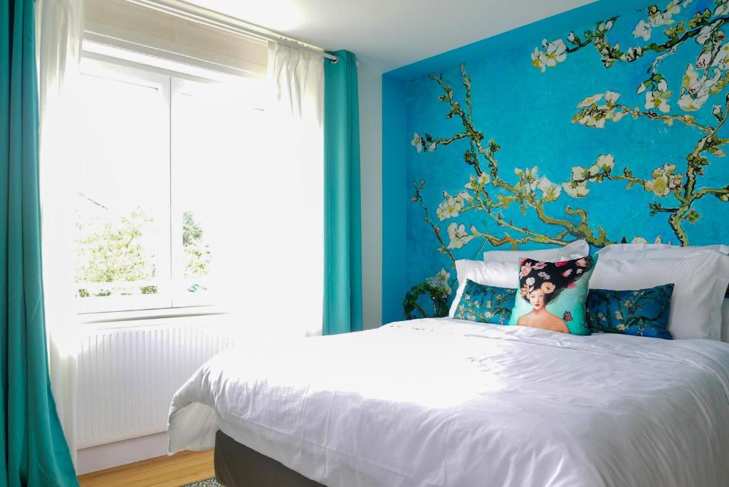 科尔马Maison 1934 - Colmar Gare & Parking gratuit的一间卧室配有一张蓝色墙壁的床