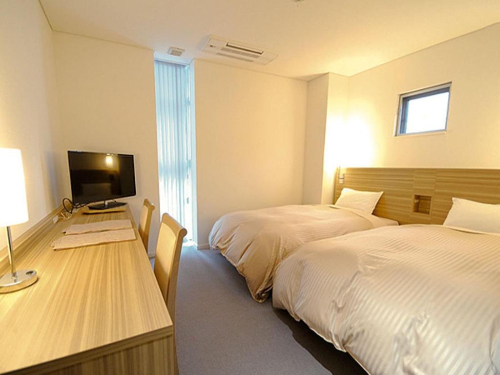 YabuPure Hotel - Vacation STAY 44185v的酒店客房设有两张床和一张书桌及电视