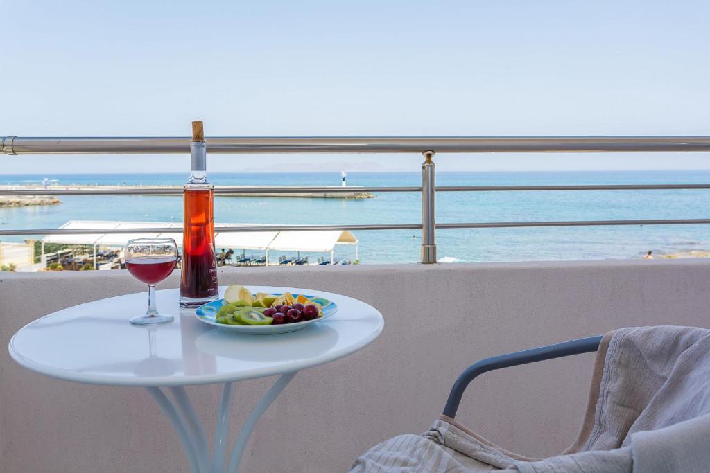 古瓦伊Sole Mare Seaside Apartments的一张桌子,上面放着一杯葡萄酒和一盘食物