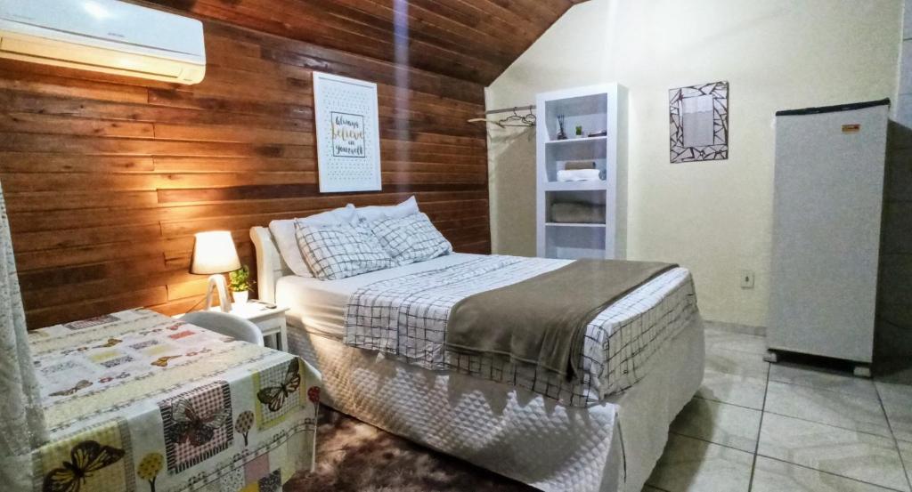 雷森迪Chalé suíte com ar em Resende的一间卧室设有两张床和木墙