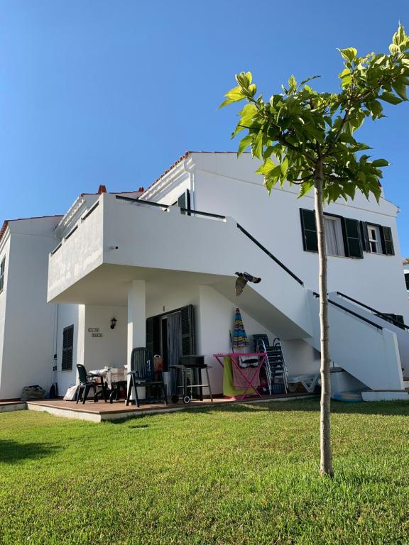 阿雷纳尔登卡斯特尔Ca la Marta apartamento con piscina y jardín a 150m de la playa的院子里有树的白色房子