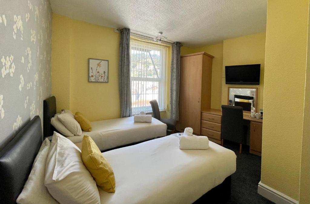 兰迪德诺Milverton House的酒店客房配有两张床和一张书桌
