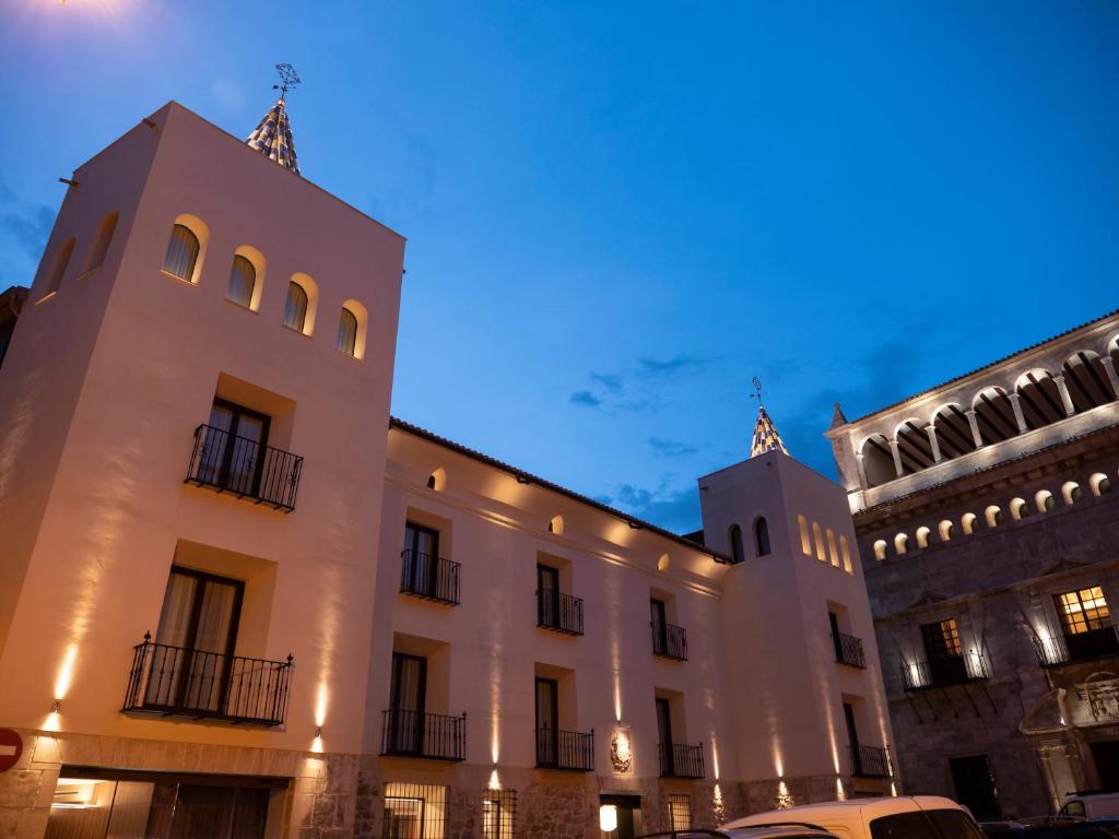 特鲁埃尔Hotel Palacio La Marquesa 4 Estrellas SUP的一座建筑,有两座塔楼,前面有一辆汽车