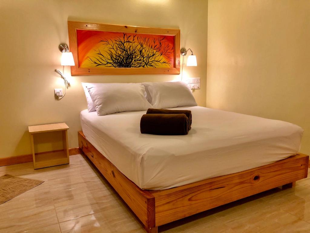 马提威力Royal Reef Stay的卧室配有一张大床,墙上挂有绘画作品