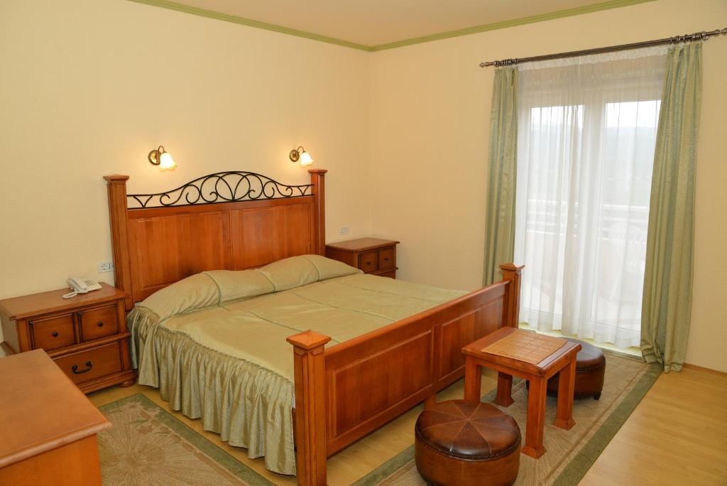 伊莫茨基Hotel Venezia Imotski的一间卧室设有一张大型木床和一个窗户。