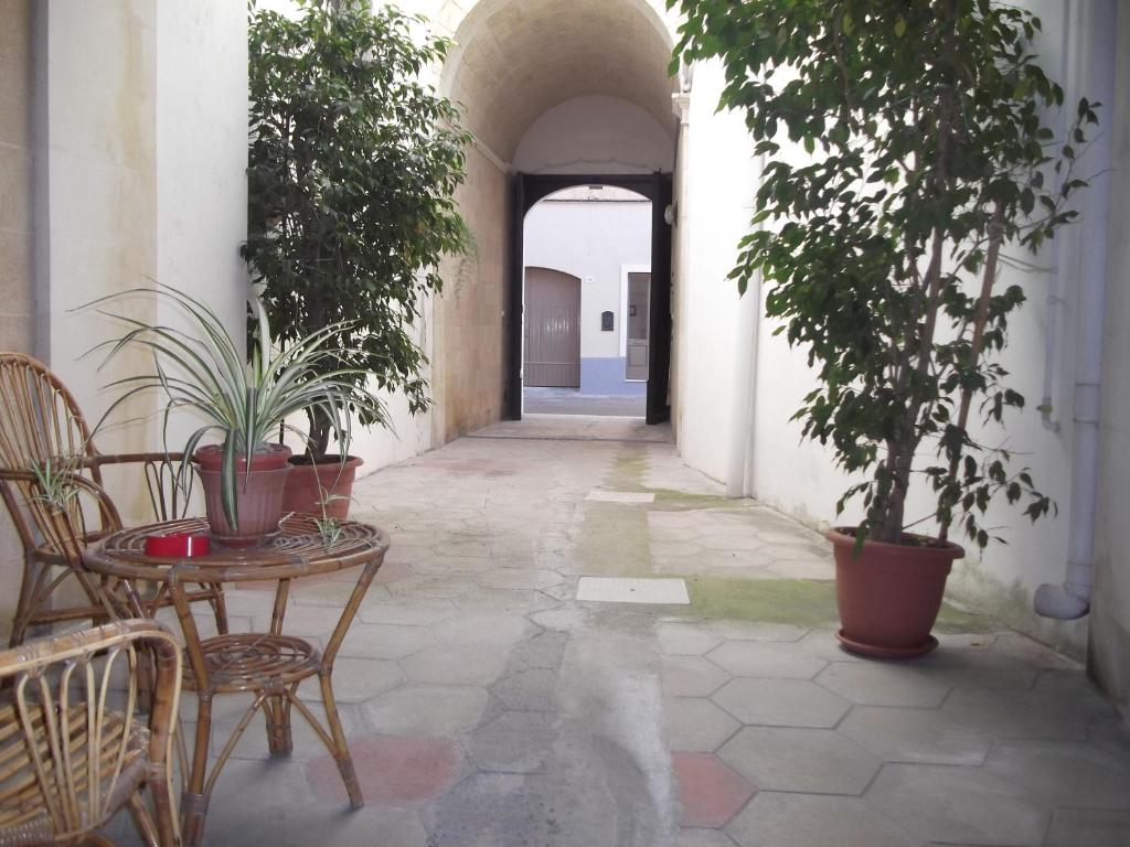 莱魁勒B&B La Corte的一条带桌椅和植物的空走廊