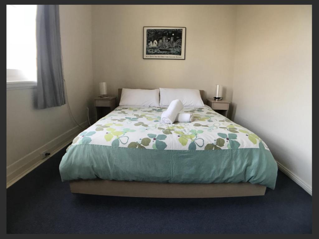 墨尔本Malvern Backpackers的一间卧室配有一张带绿色和黄色棉被的床