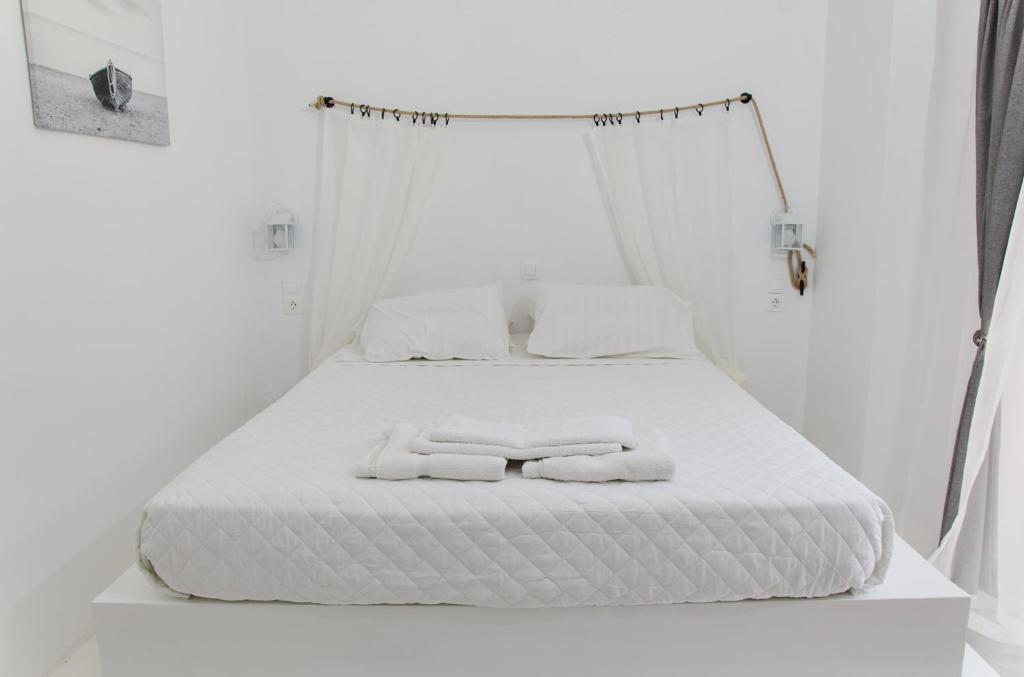 阿吉亚玛丽娜Golden Star Praxitelous的一张白色的床,上面有两条毛巾