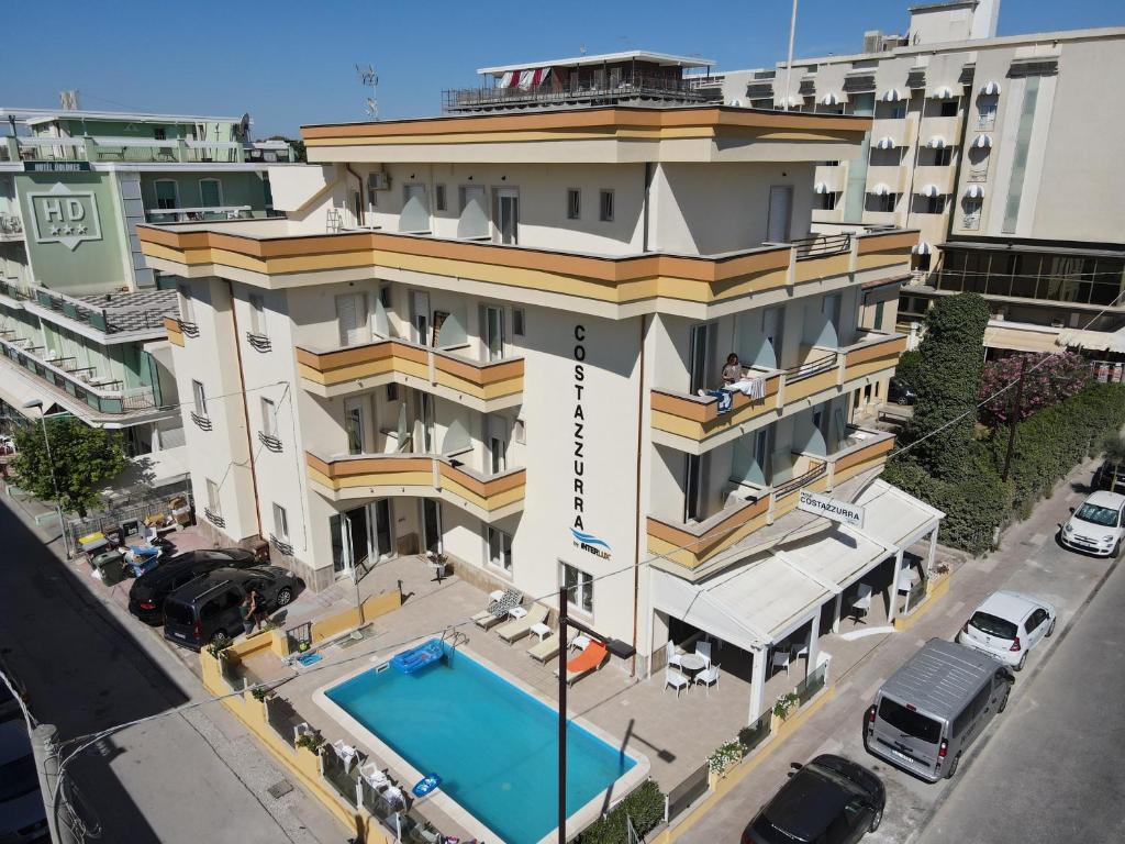 里米尼Hotel Costazzurra by Interlux的享有带游泳池的大楼的顶部景致