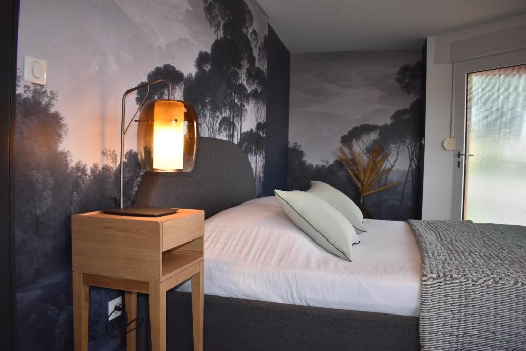圣伊波利特Chez Max Alsace的一间卧室配有一张带台灯的床铺,