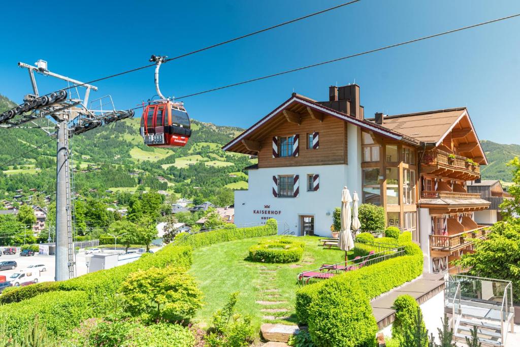 基茨比厄尔Hotel Kaiserhof Kitzbühel, 4 Sterne Superior的山丘上带缆车的房屋