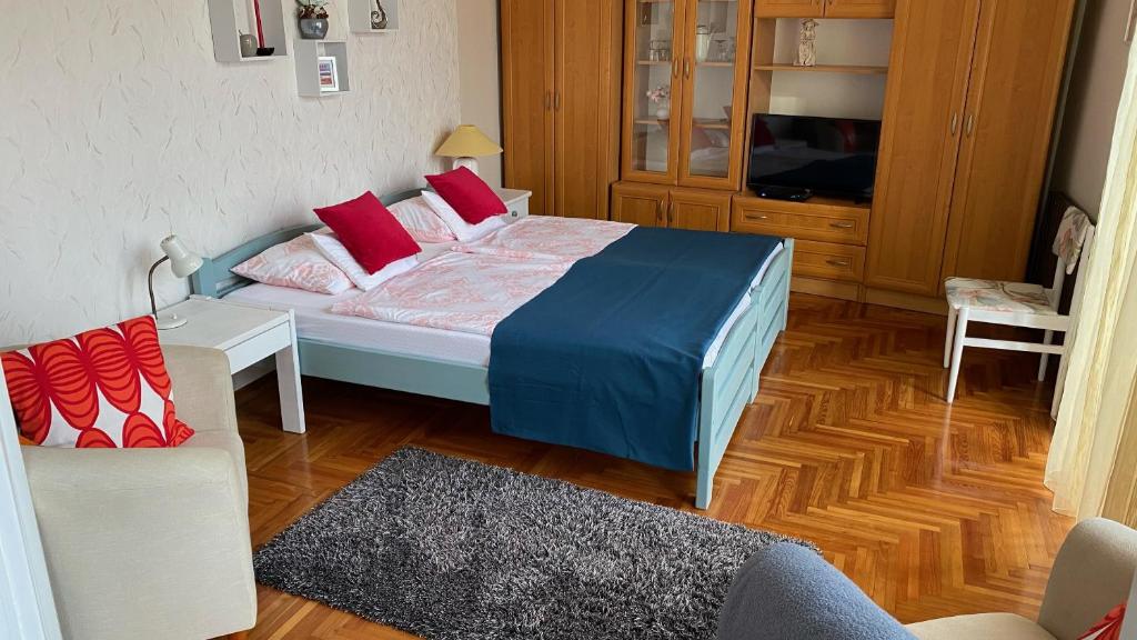 埃格尔Balàzs Apartman的一间卧室配有一张床、一台电视和一张沙发