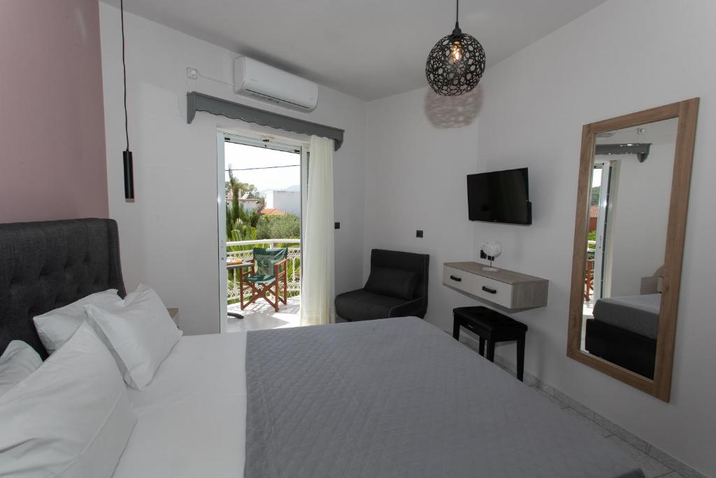 阿穆迪亚科勒套房酒店的一间卧室配有一张床、镜子和椅子