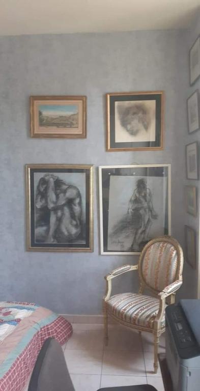 戛纳Private room full furnished in cannes的卧室配有墙上的图片和椅子