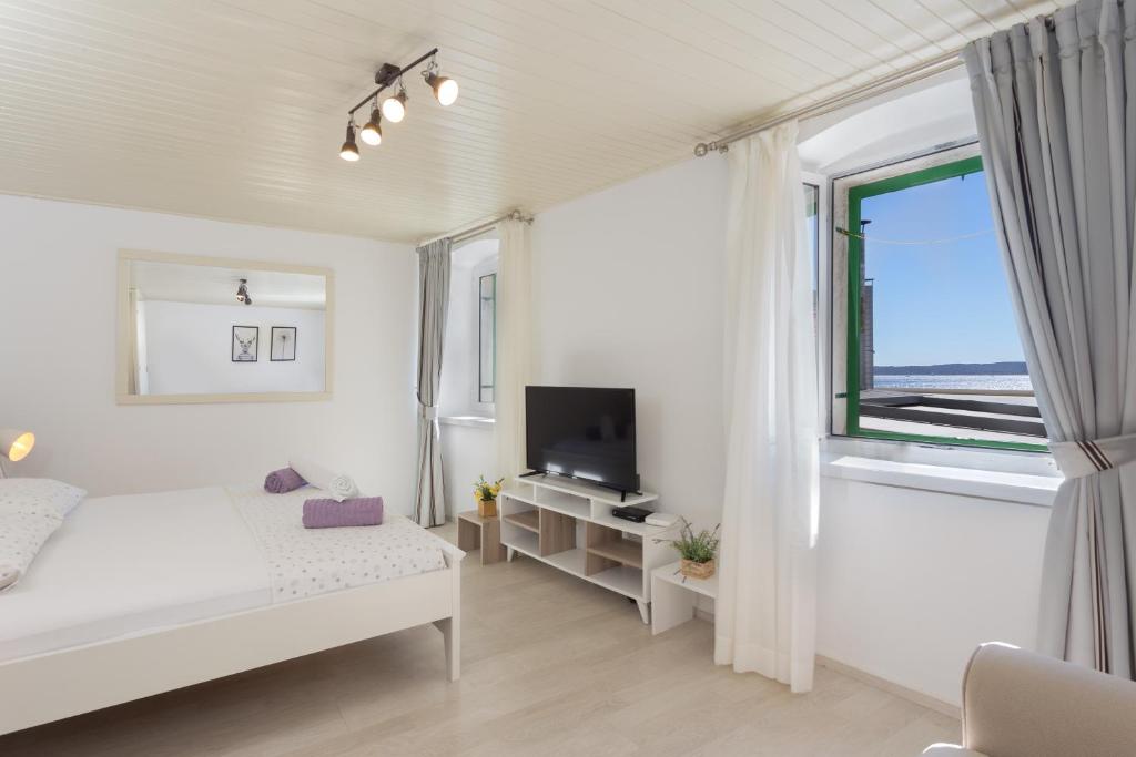 赫瓦尔Apartment Petric的白色的卧室设有床和窗户