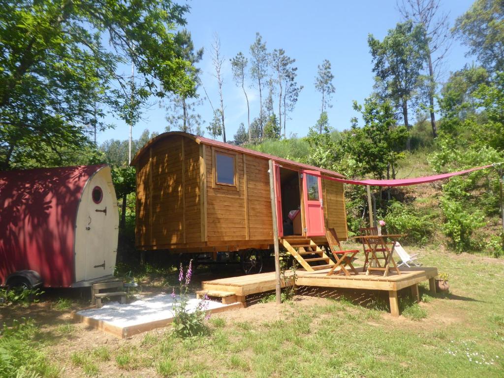 大佩德罗冈Rosa the Cosy Cabin - Gypsy Wagon - Shepherds Hut, RIVER VIEWS Off-grid eco living的田野里的一个小房子和一辆拖车
