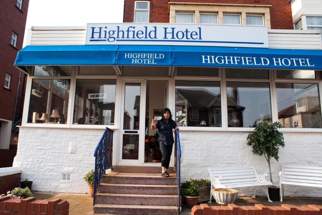 布莱克浦海菲尔德私人酒店 的站在高地酒店门口的女人