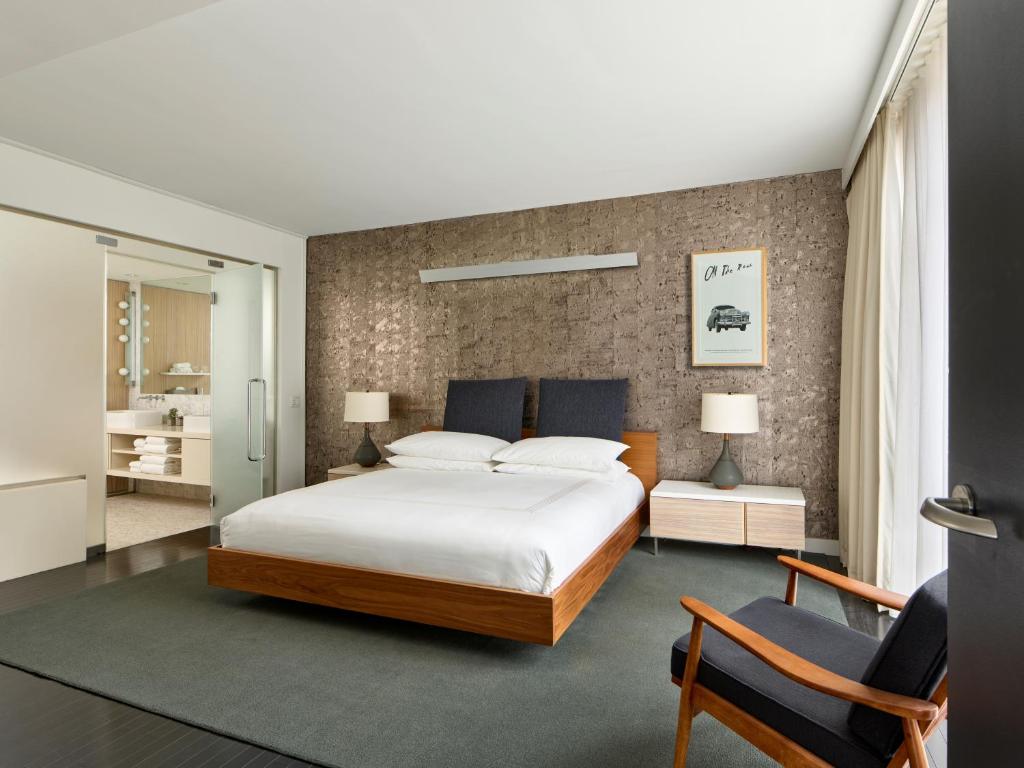 纽约Smyth Tribeca的一间卧室配有一张大床和两把椅子