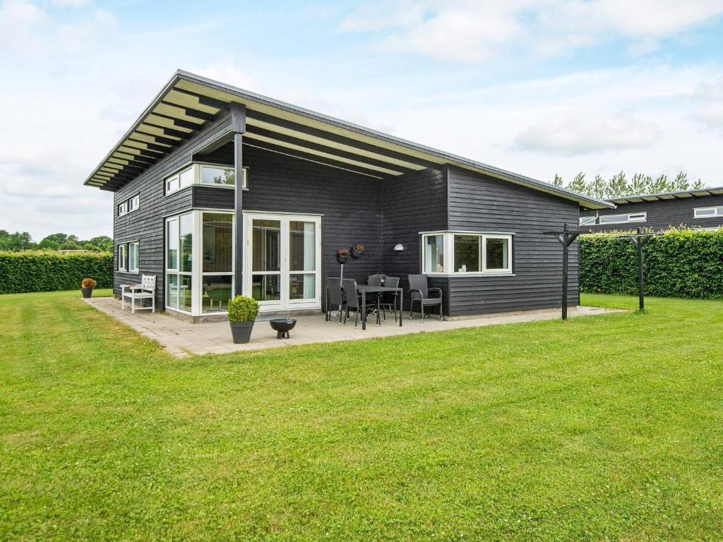 Årøsund6 person holiday home in Haderslev的黑色房屋设有庭院和草坪