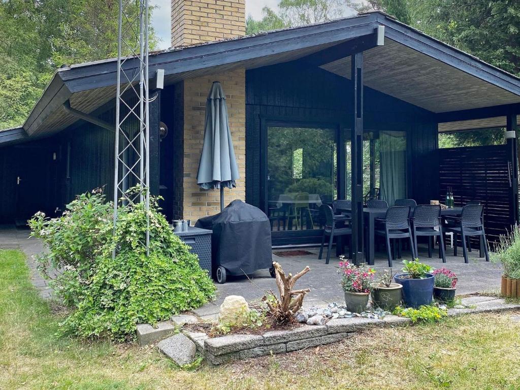博托比瓦格吕斯44号三卧室度假屋的房屋设有带遮阳伞的庭院