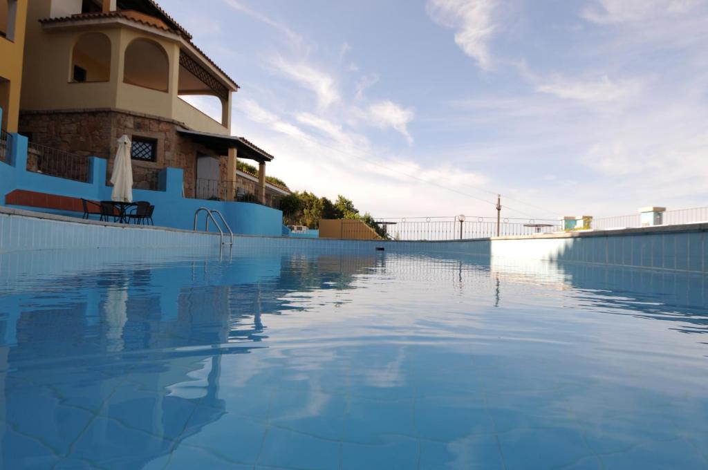 巴哈撒丁岛Vallemare Residence e Studios的大楼前的蓝色海水游泳池