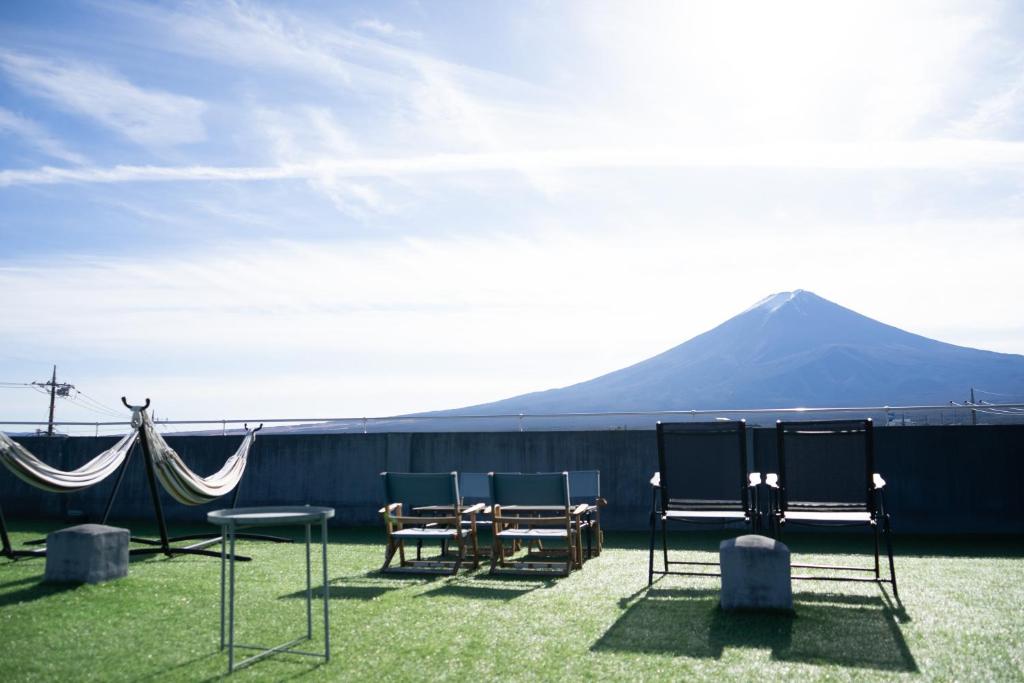 富士河口湖Fuji Guest House Ao的一组桌椅,背景是山