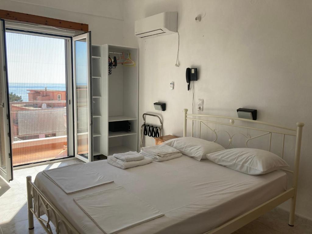 波罗斯Hotel Galini的卧室内的一张床铺,设有大窗户