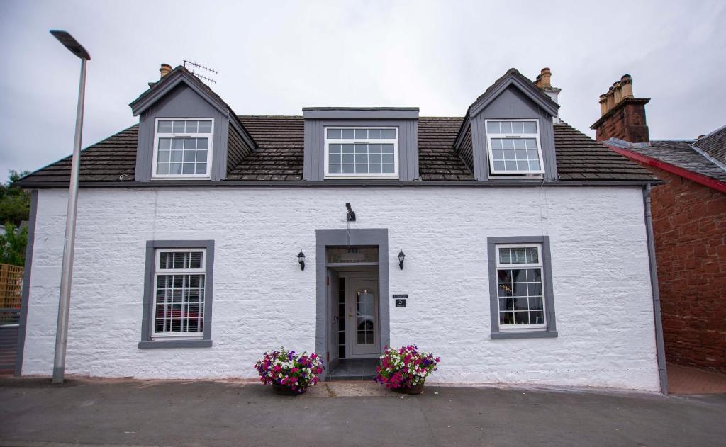 德里门Braeside Guest House, Loch Lomond的前面有鲜花的白色房子