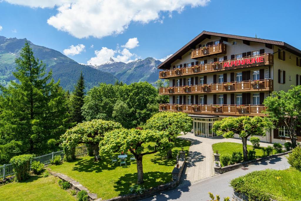 翁根Hotel Alpenruhe - Vintage Design Hotel的背景是一座花园和山脉的酒店