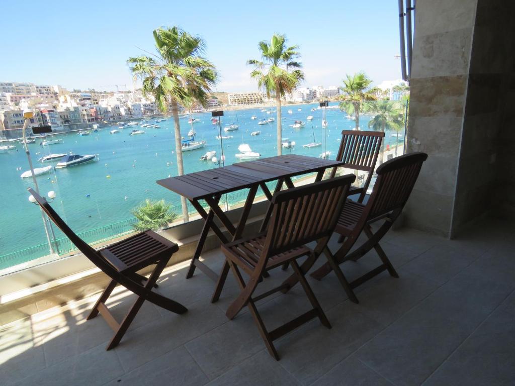 马尔萨斯卡拉Aquamarine Sea Front Apartments - Second Floor的阳台配有桌椅,享有水景
