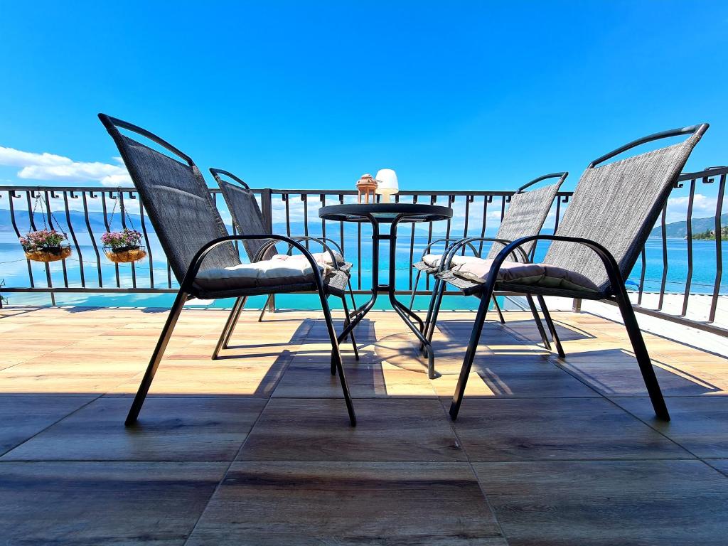 特佩杰卡Apartmani Rustik Trpejca的一张桌子和椅子,位于俯瞰着水面的甲板上