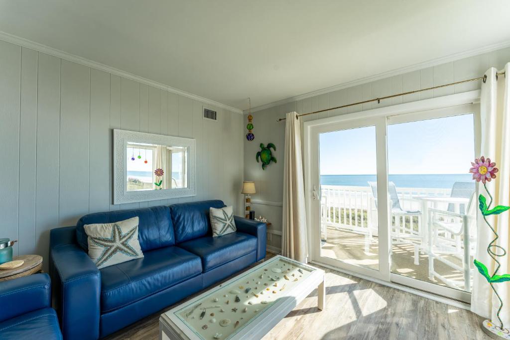 默特尔比奇Charming Ocean-view Condo at Ocean Pier 3的客厅配有蓝色沙发,享有海景
