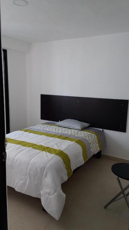 瓜达拉哈拉Casa Zona Iteso, Expo, Plaza del Sol, 4 habitaciones 8 huespedes / compartida的一间卧室配有一张大床和黑色床头板