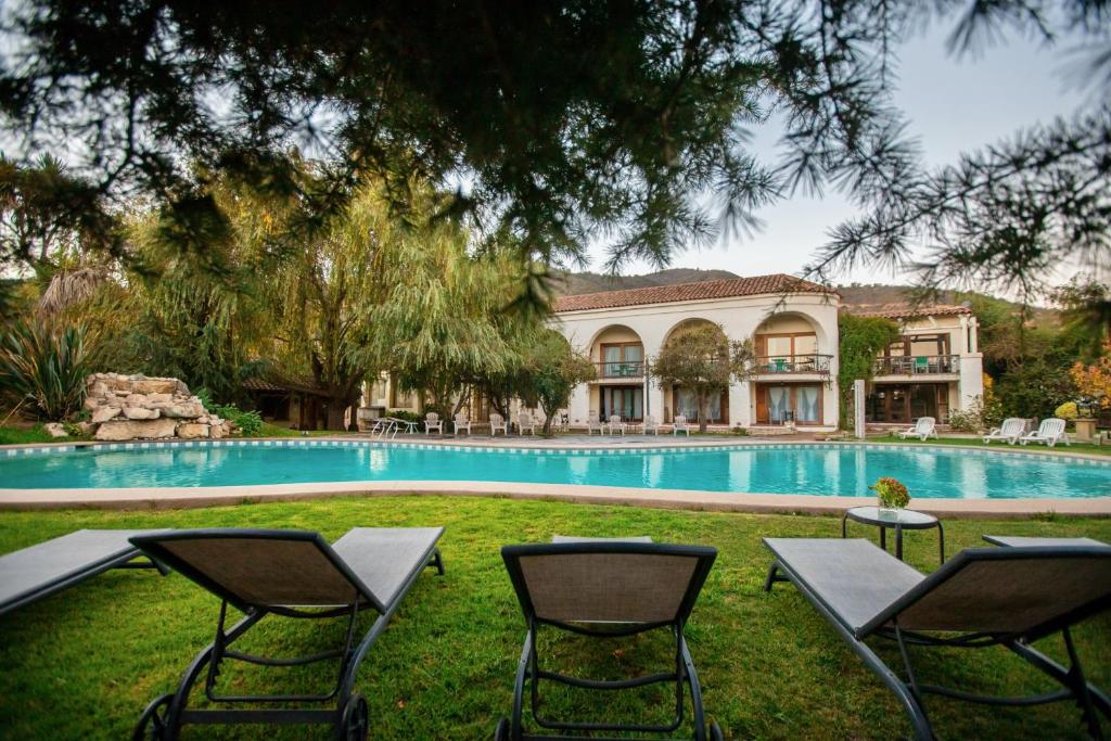 卡萨布兰卡Hotel Casablanca Spa & Wine的庭院内带游泳池及椅子的房子