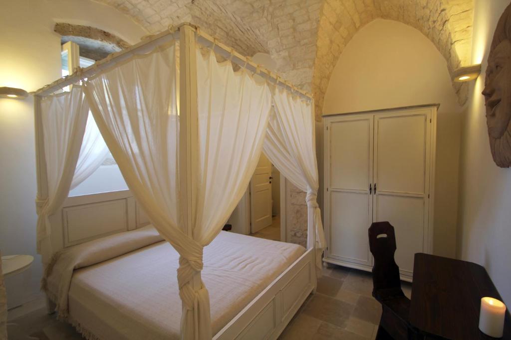 奥斯图尼La Vecchia Tabaccheria B&B的一间卧室配有一张天蓬床和窗户