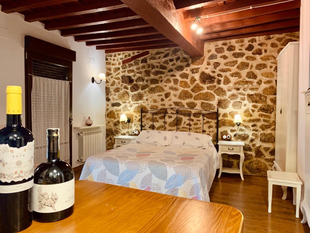 巴尼奥斯德蒙特迈奥尔Casa tio Basilio的一间卧室配有一张床和两瓶葡萄酒