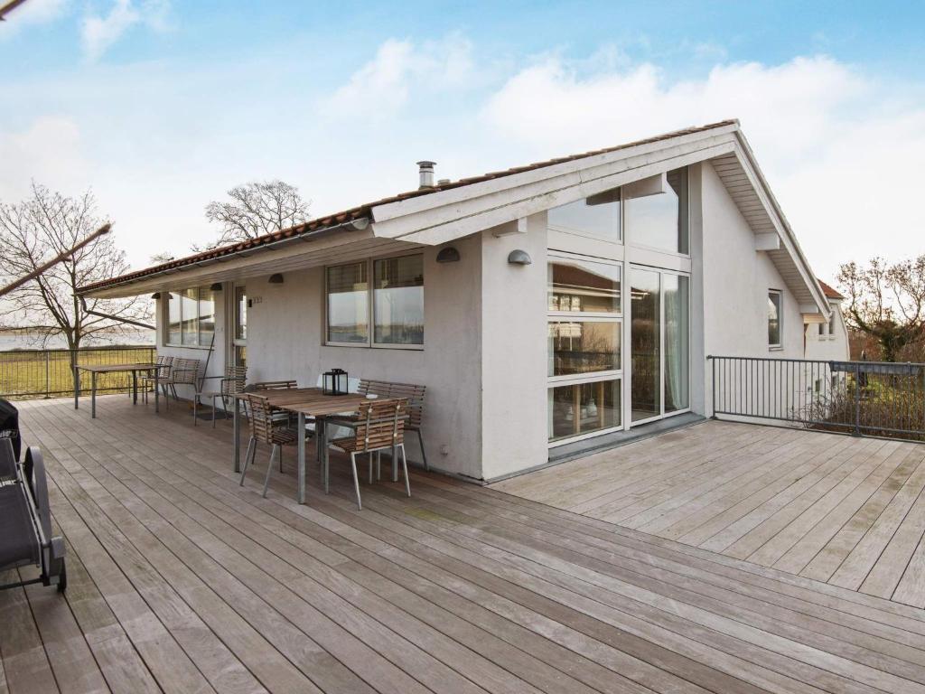 Årøsund12 person holiday home in Haderslev的房屋设有1个带桌椅的甲板