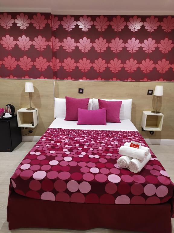马德里马德里客栈旅馆的卧室配有一张紫色床,墙上挂着粉红色的鲜花