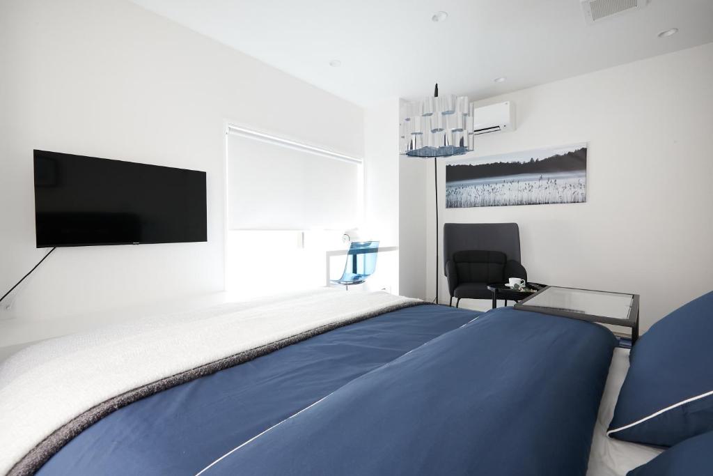 东京Designers Hotel Siesta的一间卧室配有一张大床和一台平面电视