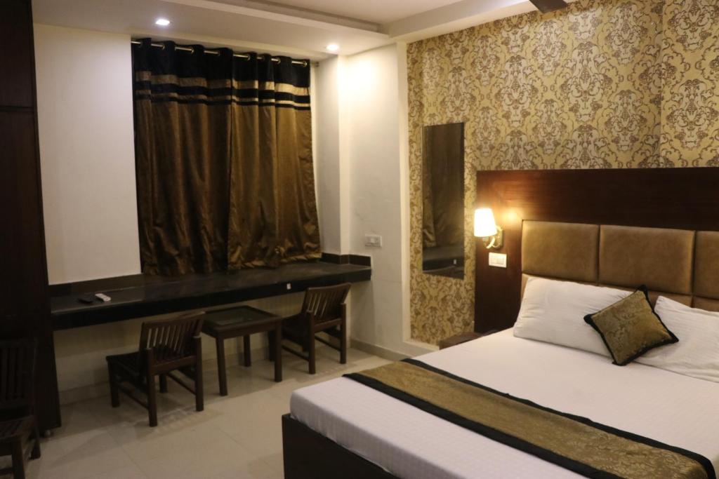 钱德加尔Hotel The Black Gold的配有一张床和一张书桌的酒店客房