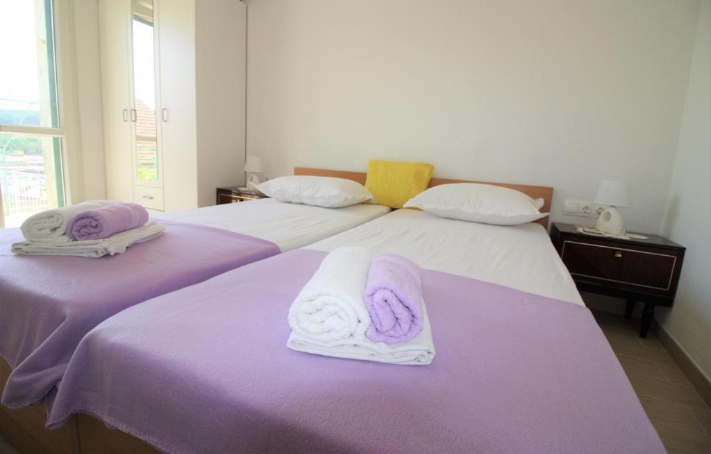 苏曼婷Privatna Soba Gita的两张带紫色和白色毛巾的床