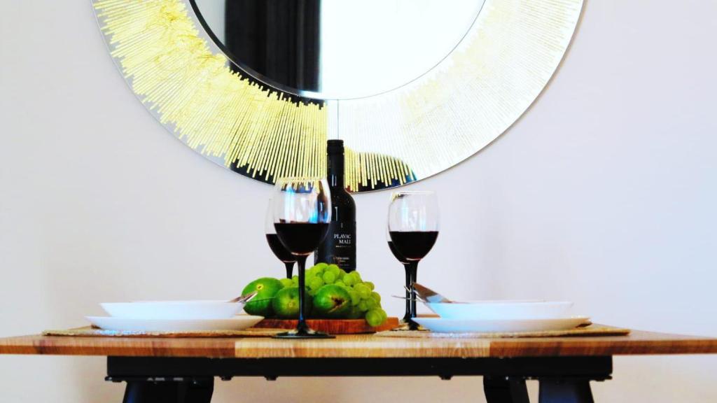 斯普利特Casari rooms & apartments的一张桌子,上面放着两杯葡萄酒和一面镜子