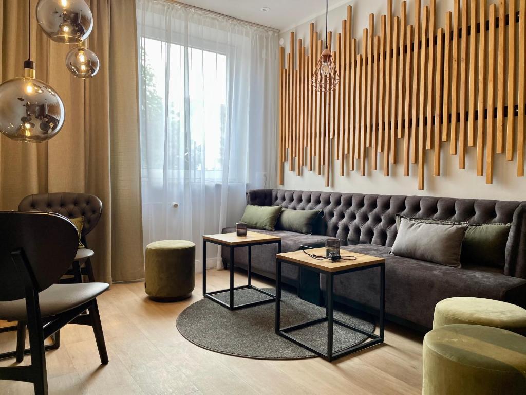 哈默尔恩Hotel Schultheiss Hameln的客厅配有沙发和2张桌子