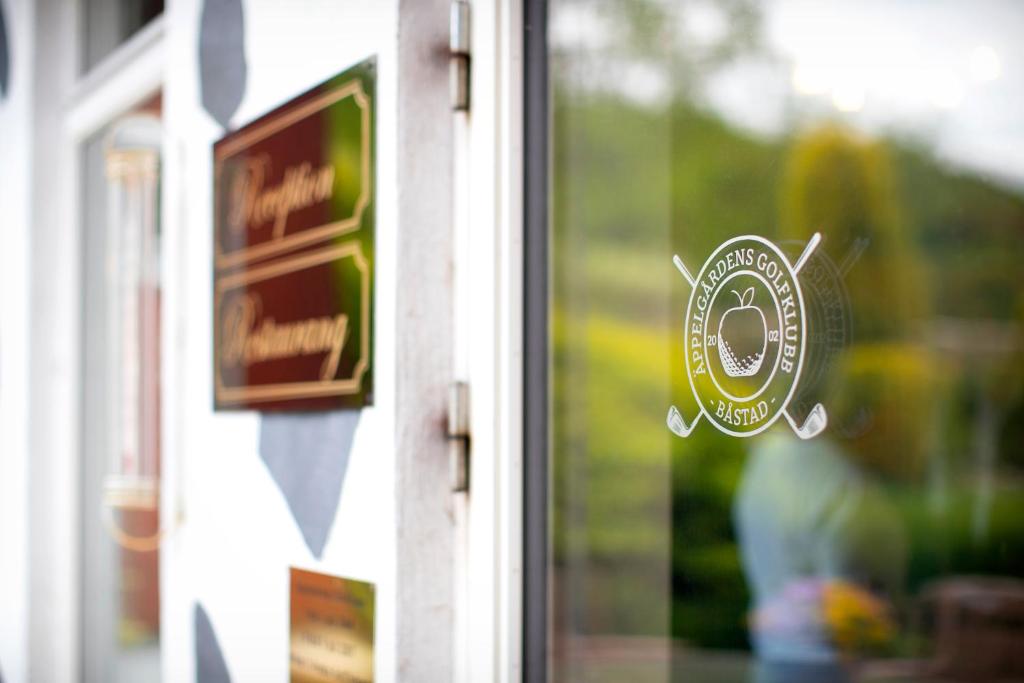 巴斯塔德Äppelgårdens Golfklubb的商店玻璃窗户上的贴纸