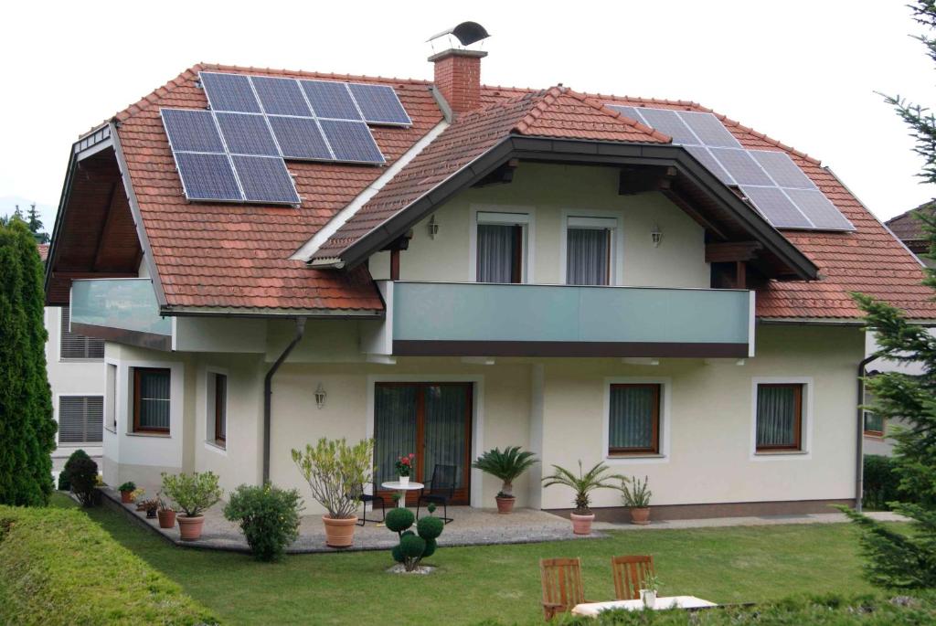 克洛派内尔湖Ferienwohnungen Gerti的屋顶上设有太阳能电池板的房子