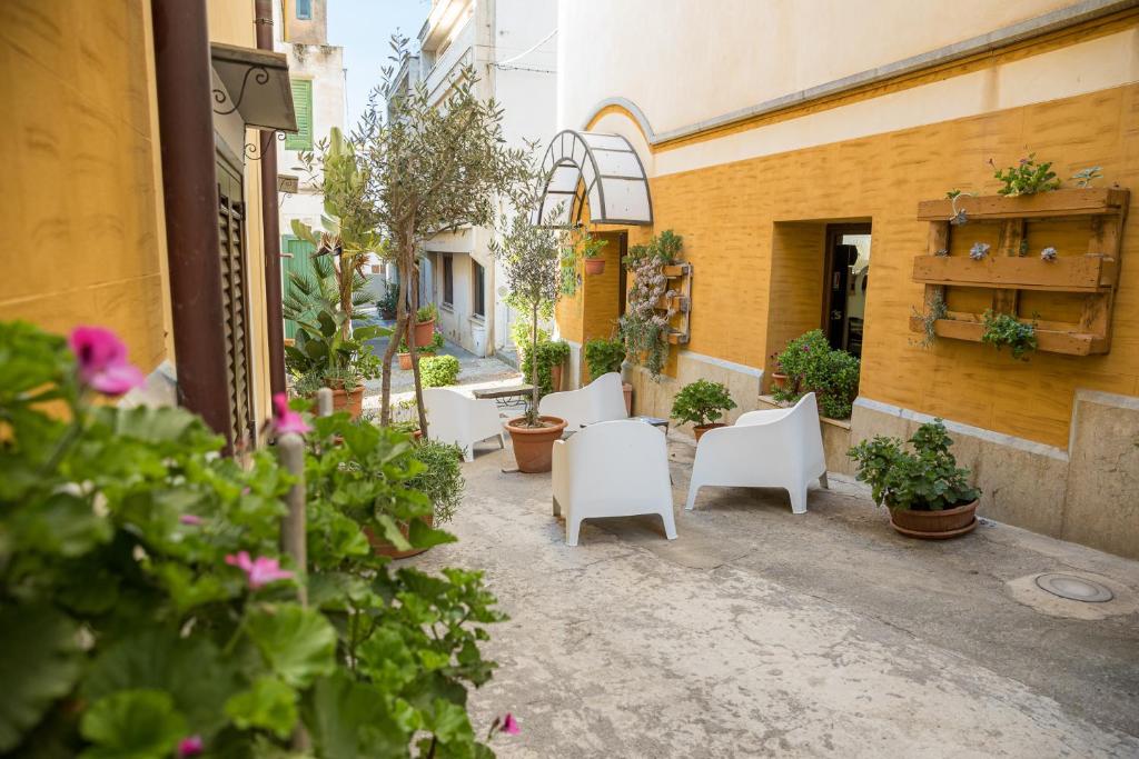 乌斯蒂卡科蕾莉雅酒店的一座庭院,里面设有白色的椅子和植物,还有一座建筑