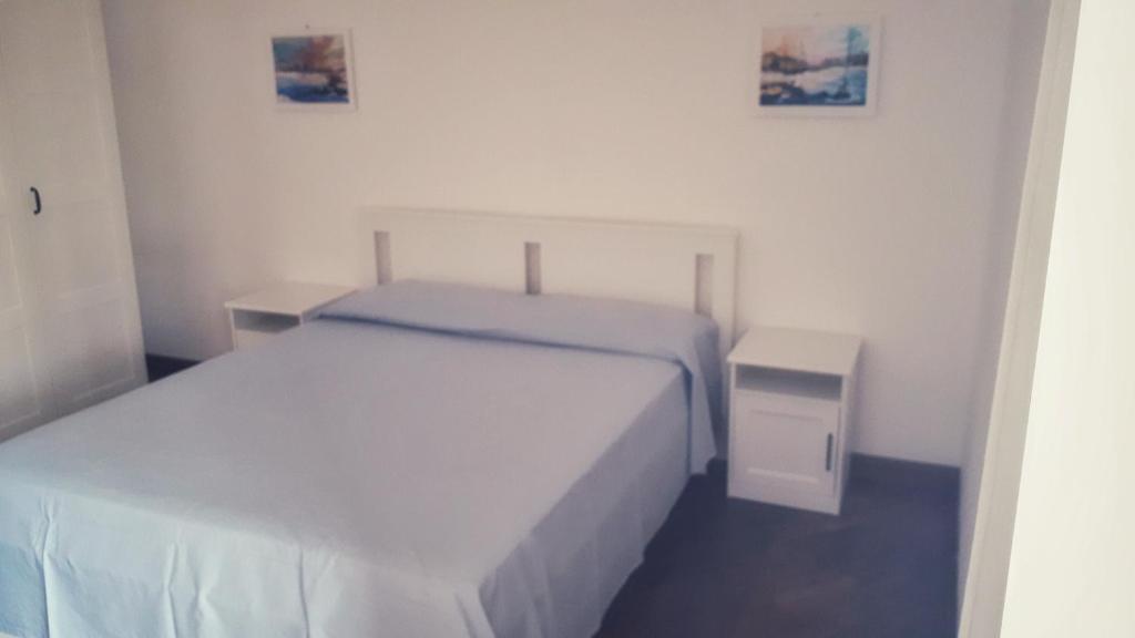圣雷莫MAX and SUN parking privato nel prezzo的一间白色卧室,配有床和床头柜