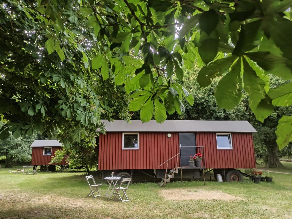GustowSchäferwagen auf dem Biogut-Saalkow的红色的小房子,配有桌子和椅子