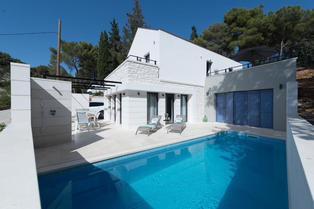 米欧纳VILLA ELEMENTA - A peaceful retreat的白色房子前的游泳池